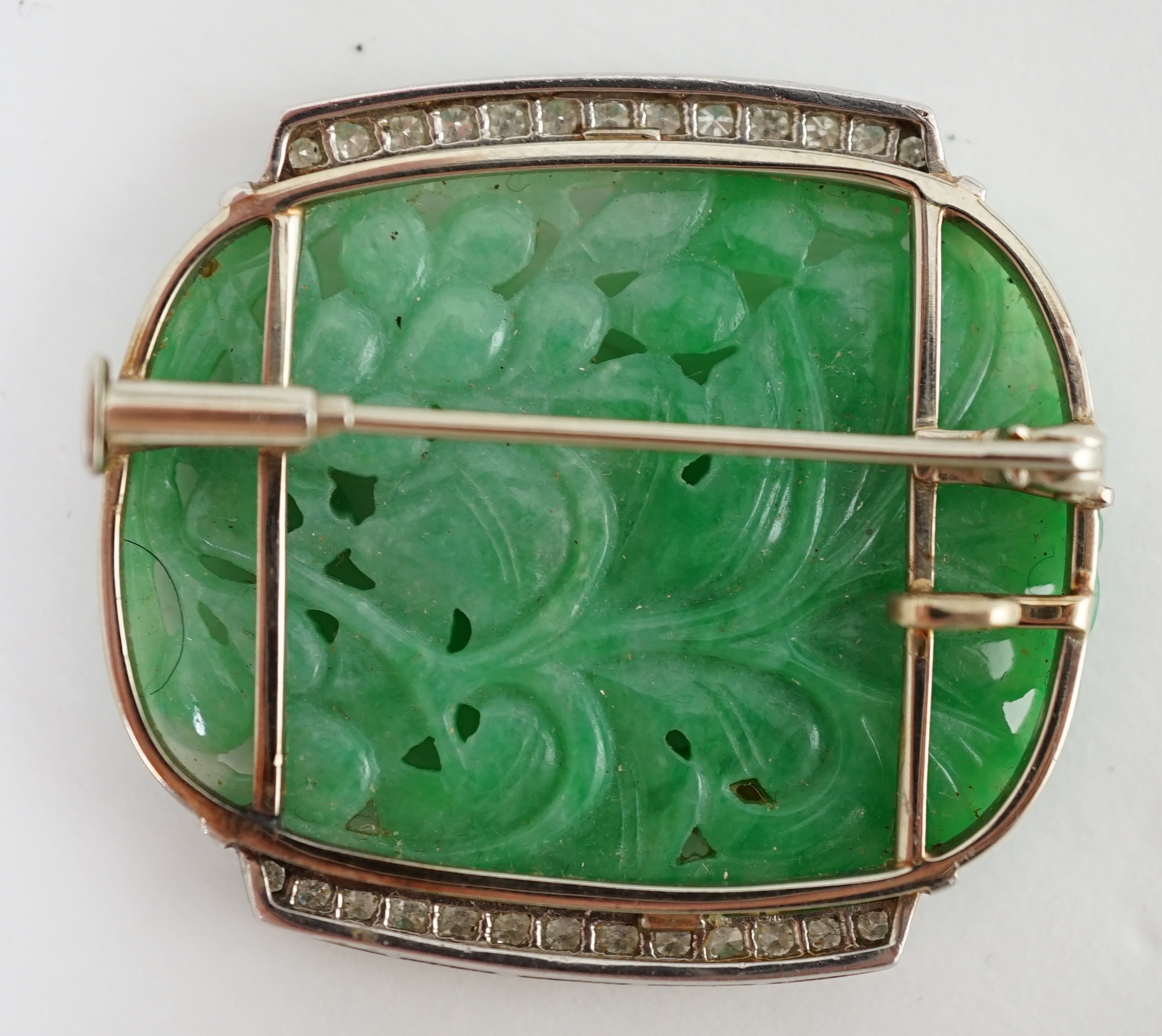 A Chinese white gold and diamond cluster set carved jade leaf and fruit brooch